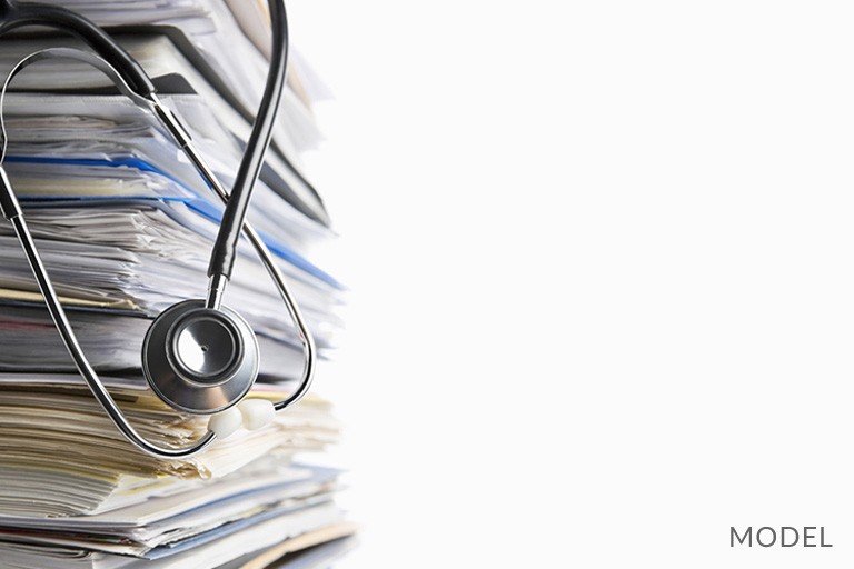 Stethoscope on Top of Stack of Medical Records